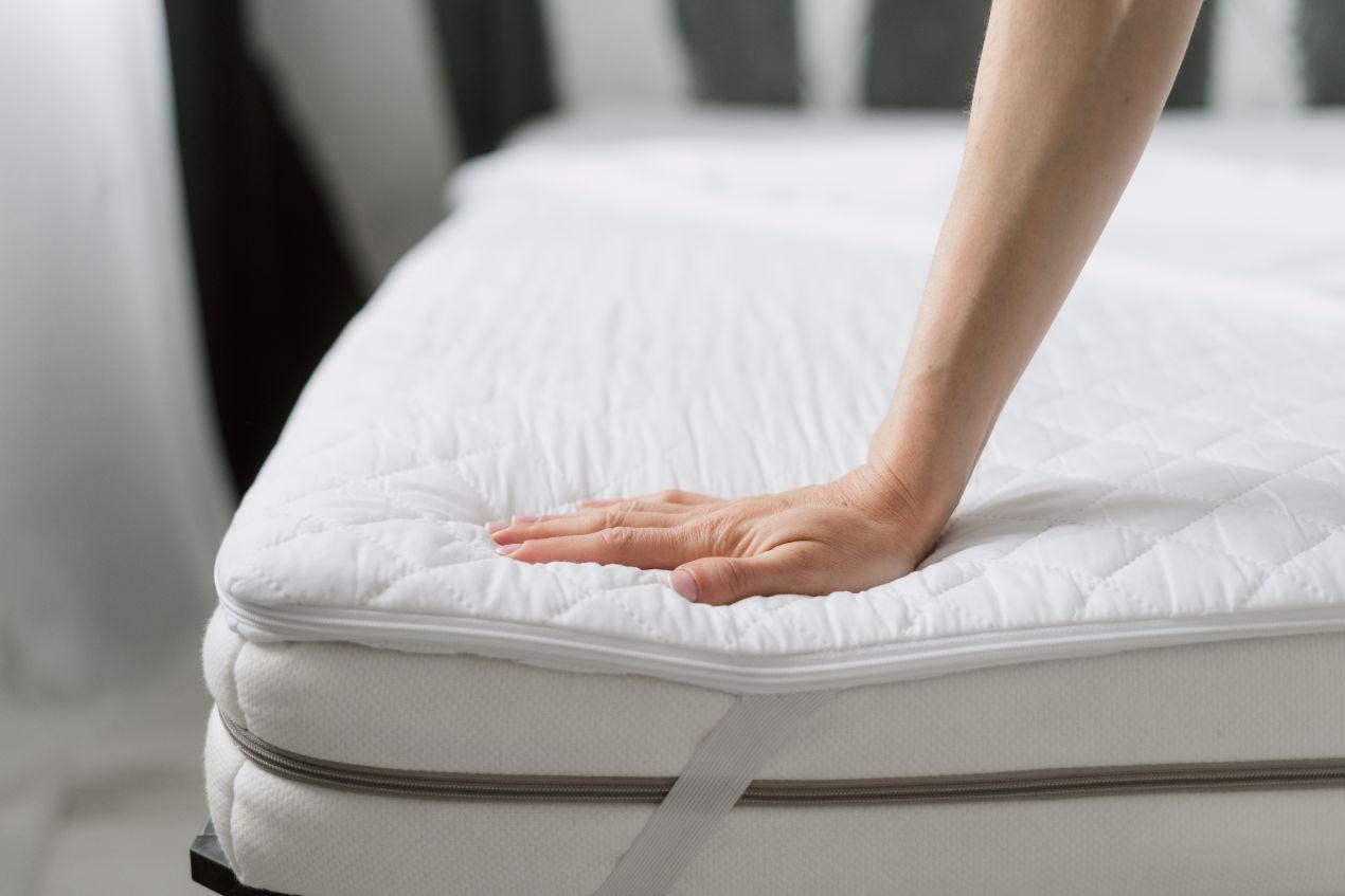 Hand prüft Matratze mit encasings als Schutzlösung gegen Hausstaubmilben und Allergene